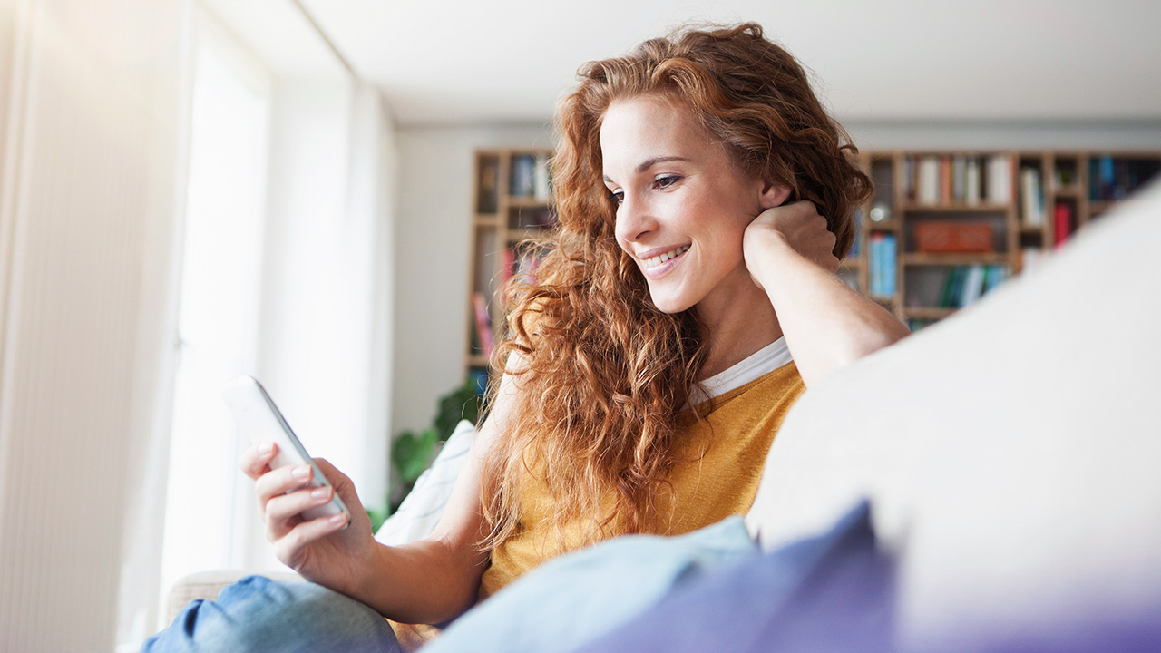 nő telefonját nézi